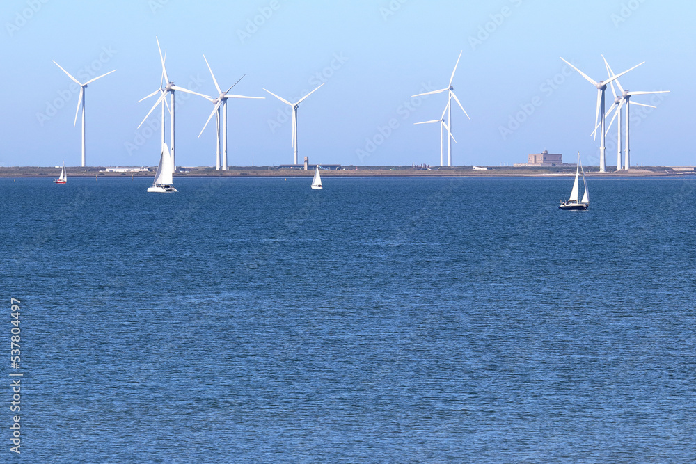 Wind power: sailing ships on the Eastern Scheldt estuary and wind turbines on the storm surge barrier, Netherlands