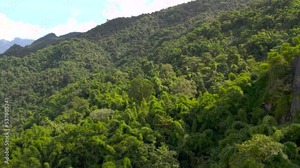 Aerial view flying above lush green tropical rain forest mountain with rain cloud cover during the rainy season on the Doi Phuka Mountain reserve national park. In, the northern Thailand. Aerial view flying above lush green tropical rain forest mountain with rain cloud cover during the rainy season on the Doi Phuka Mountain reserve national park. In, the northern Thailand.