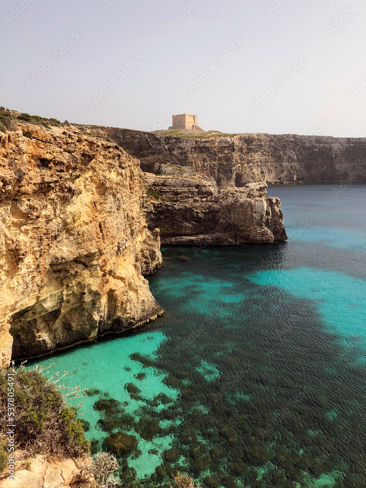 Beautiful Comino landscape (Maltese: Kemmuna), a small island of the Maltese archipelago, in the Mediterranean Sea. Maltese bird sanctuary and nature reserve. St Mary's Tower view. Maltese Blue lagoon