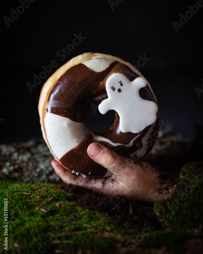 chocolate donut with ghost hand in moss ground halloween