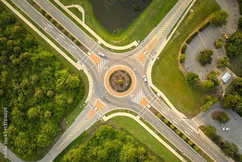 Aerial view of road roundabout intersection with moving cars traffic. Rural circular transportation crossroads