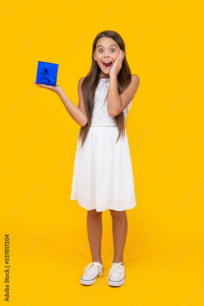 surprised teen child hold present box on yellow background surprised teen child hold present box on yellow background