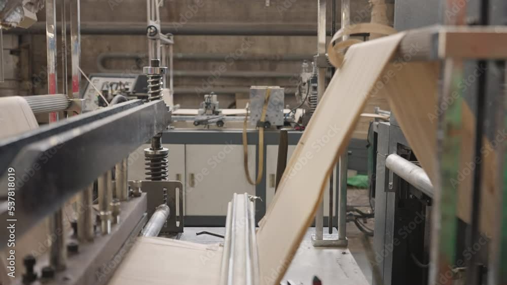 Automated fabric processing machinery used at the industrial manufacturing facility. Fabric processing machinery stretching the sustainable material. Factory machinery processing the ecological fabric Automated fabric processing machinery used at the industrial manufacturing facility. Fabric processing machinery stretching the sustainable material. Factory machinery processing the ecological fabric