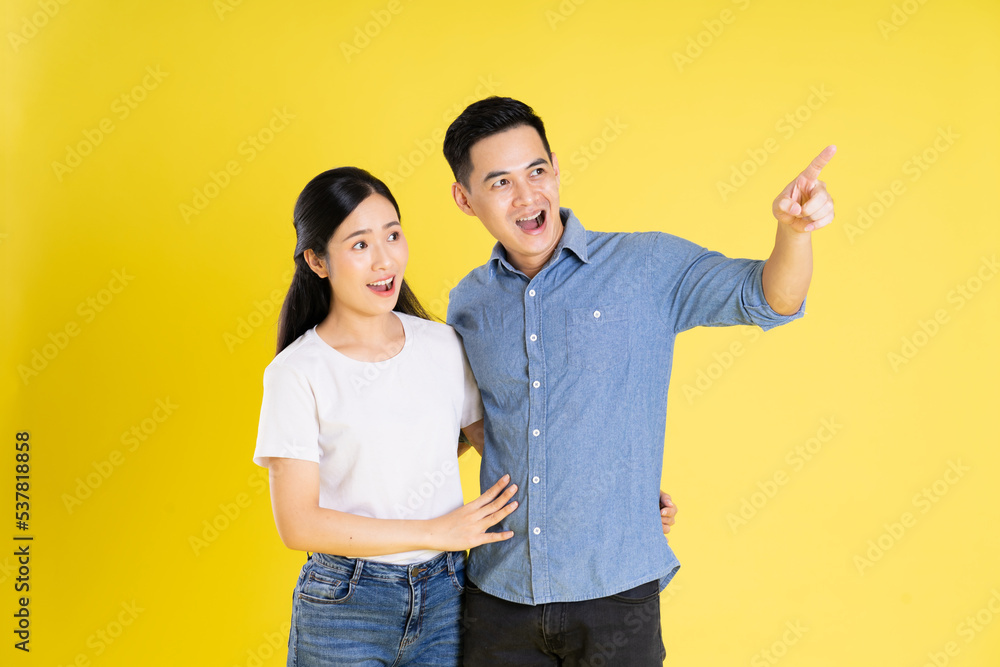 image of asian couple posing on yellow background image of asian couple posing on yellow background