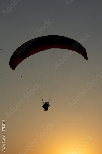 Silhouette paragliding at sunset in Oludeniz.