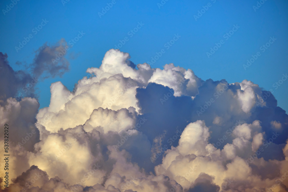 White fluffy cumulonimbus clouds forming before thunderstorm on summer blue sky. Changing stormy cloudscape weather White fluffy cumulonimbus clouds forming before thunderstorm on summer blue sky. Changing stormy cloudscape weather