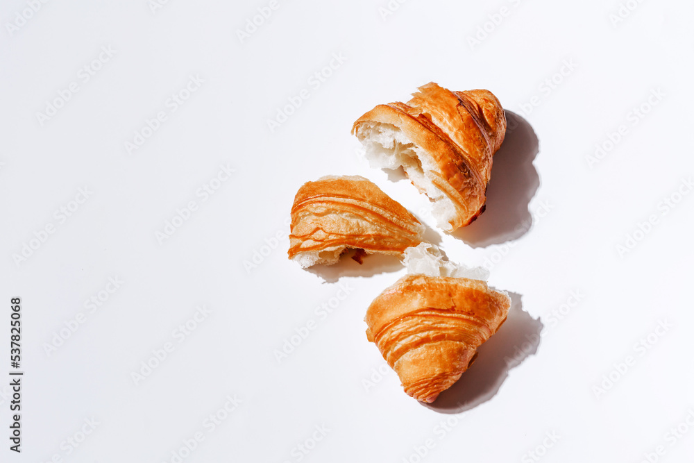 Pieces of croissant on a white background with room for text. Soft and fresh pastries top view Pieces of croissant on a white background with room for text. Soft and fresh pastries top view