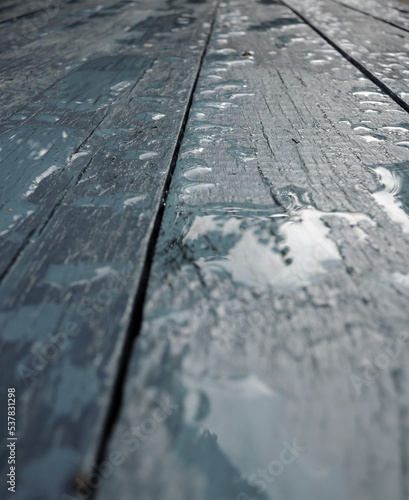 Wooden planks painted in loft style with water drops and puddles angle view vertical background  