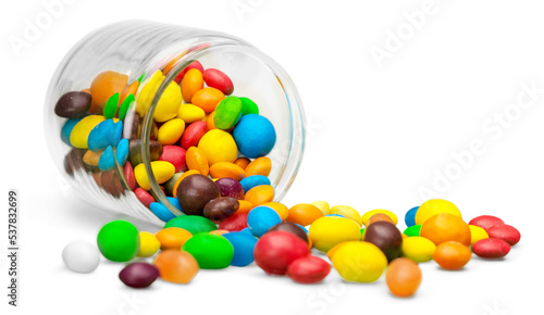 Foto Colorful candies sweets falling out of a glass jar, composition isolated over th