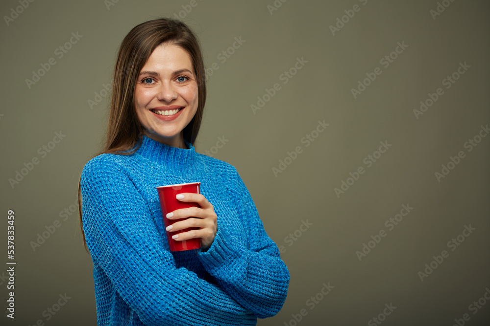 Smiling woman warming with hot drink in big red mug. Isolated portrait. Smiling woman warming with hot drink in big red mug. Isolated portrait.