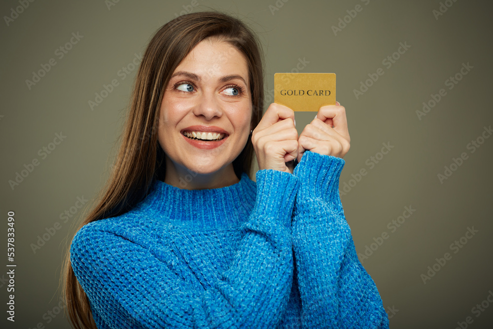 Smiling woman holding credit card and looks at it. Isolated female portrait. Smiling woman holding credit card and looks at it. Isolated female portrait.