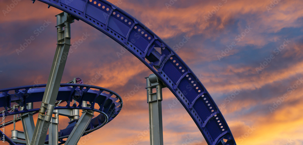 Attraction roller-coaster (switchback) against the background of a romantic evening sky