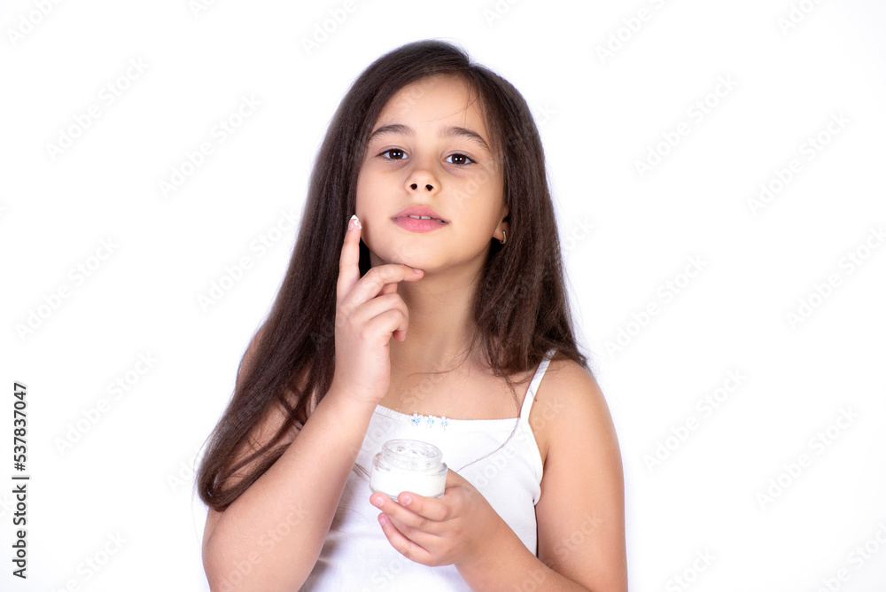 Happy child presenting beauty cosmetic product of facial skin cream Happy child presenting beauty cosmetic product of facial skin cream