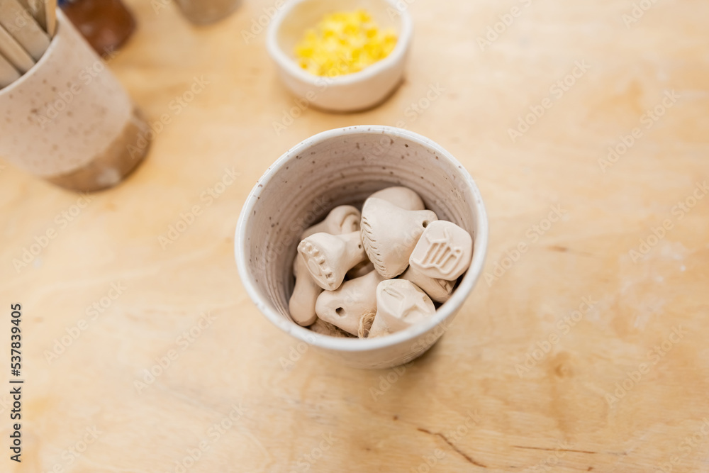 Top view of clay souvenirs in bowl in pottery workshop. Top view of clay souvenirs in bowl in pottery workshop.