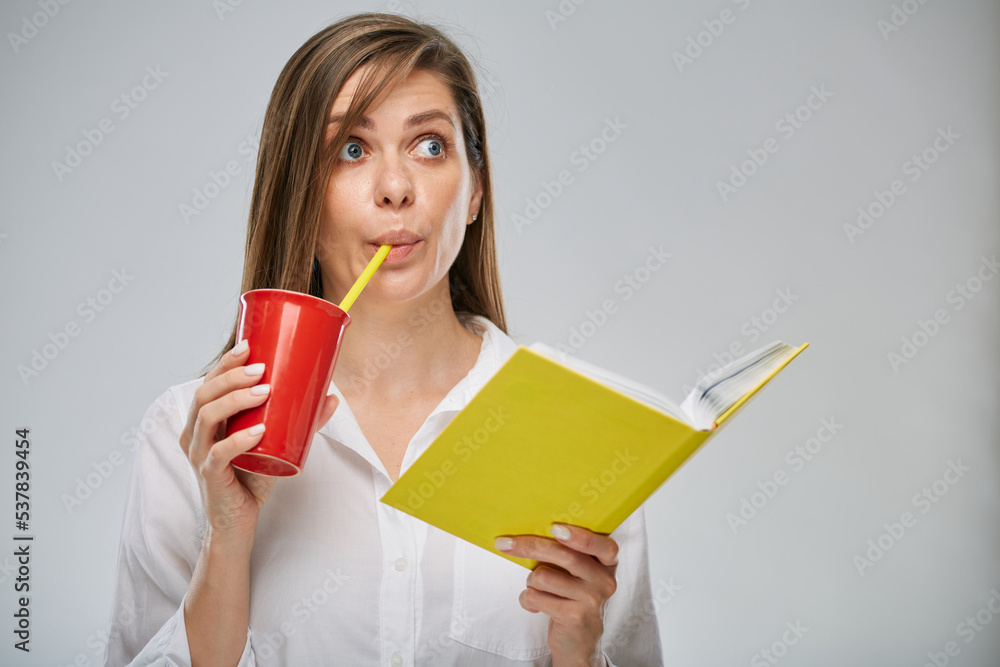 Funny face woman holding open book and drinking from red glass. Isolated advertising portrait. Funny face woman holding open book and drinking from red glass. Isolated advertising portrait.