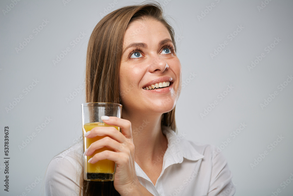 Smiling woman looking up holding orange juice. Isolated female advertising portrait. Smiling woman looking up holding orange juice. Isolated female advertising portrait.