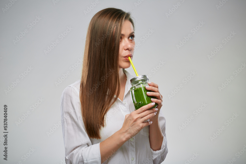 Young woman drinking green smoothie looking up. Isolated female advertising portrait. Young woman drinking green smoothie looking up. Isolated female advertising portrait.