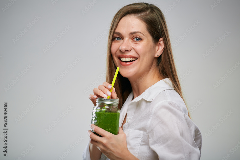 Young woman drinking green smoothie from glass jar. Isolated advertising female portrait. Young woman drinking green smoothie from glass jar. Isolated advertising female portrait.