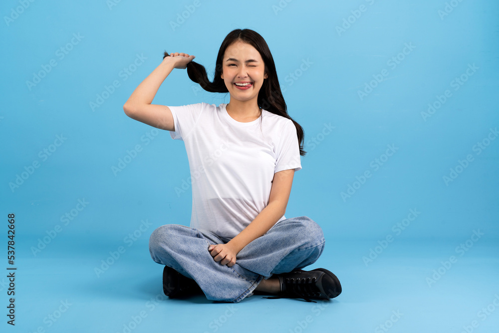 Beautiful girl sitting doing various poses On a blue background. Beautiful girl sitting doing various poses On a blue background.
