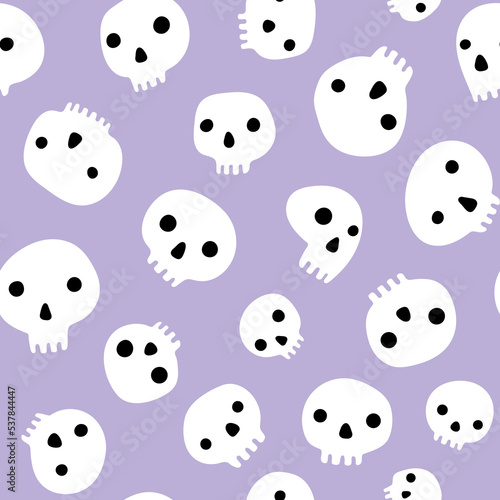 Cute skulls scattered on pastel purple background Halloween seamless pattern.