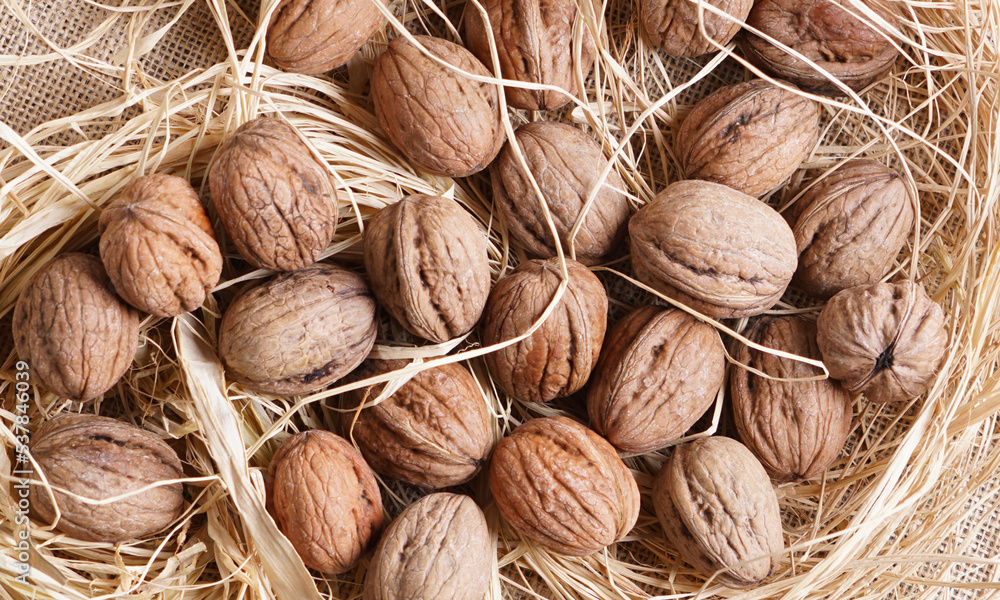 walnuts in a basket on a brown background walnuts in a basket on a brown background