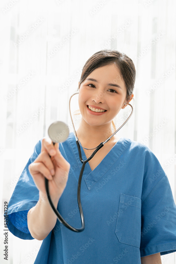 Professional woman doctor with assured expression, Smiling Asian Female doctor in blue medical uniform with stethoscope, Medical concept of healthcare workers Professional woman doctor with assured expression, Smiling Asian Female doctor in blue medical uniform with stethoscope, Medical concept of healthcare workers