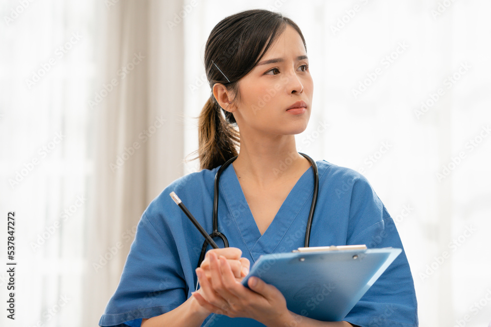 Asian Female doctor in blue medical uniform with stethoscope holding a folder of the work record, Medical concept of healthcare workers Asian Female doctor in blue medical uniform with stethoscope holding a folder of the work record, Medical concept of healthcare workers