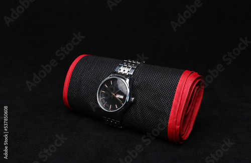 Nice luxury man's wrist watch on dark background. Stainless steel man's wrist watch with black leather strap. photo