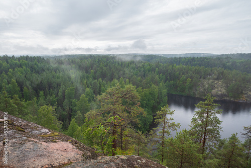 Fog raising over the lake, rocks and forest in the Repovesi National Park after the rain on cloudy summer day. View from Katajavuori Hill
 photo