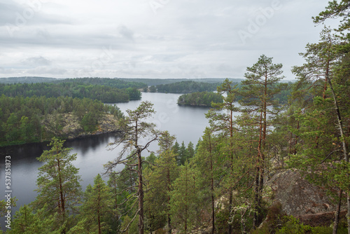 Fog raising over the lake, rocks and forest in the Repovesi National Park after the rain on cloudy summer day. View from Katajavuori Hill photo