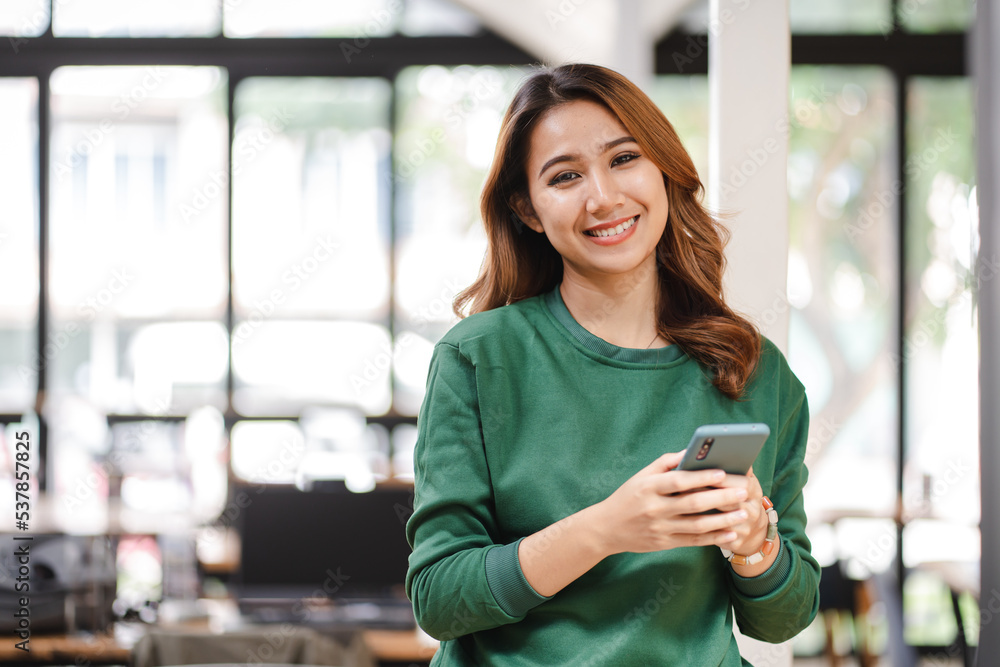 Portrait of an Asian woman holding a smartphone, typing messages, chatting with friends. on social networks mobile application concept Shopping online, browsing the web, ordering food Portrait of an Asian woman holding a smartphone, typing messages, chatting with friends. on social networks mobile application concept Shopping online, browsing the web, ordering food