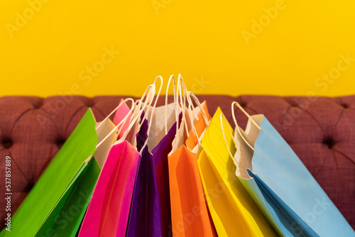 Shopping bags on the sofa. Yellow background. It can be use as a template.