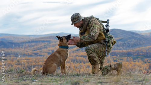 Soldier looks into the eyes of his faithful friend - a dog of the Malinois breed. © Stavros