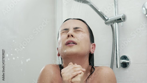Woman shivering while washing under cold water