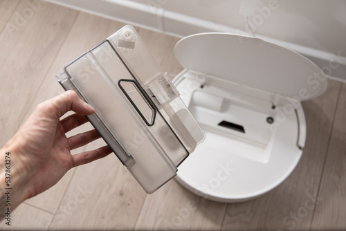 cleaning white robot vacuum cleaner from debris