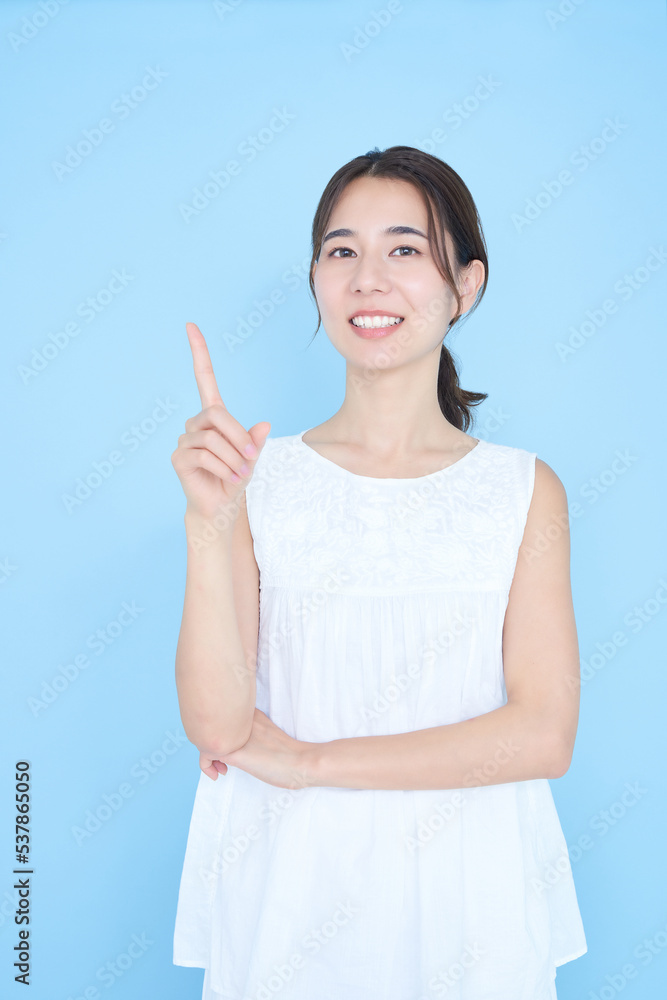 人差し指を立てるポーズをする若い女性