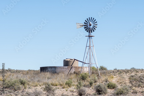 Windmill with a watertank inside an old corrugated iron dam