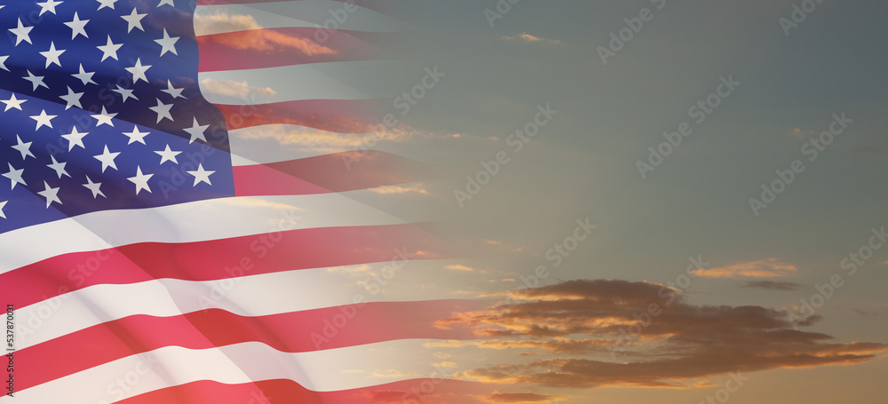 Fototapeta premium United States of America flag on sky at sunset or sunrise background. Independence day, Memorial day, Veterans day. Banner.