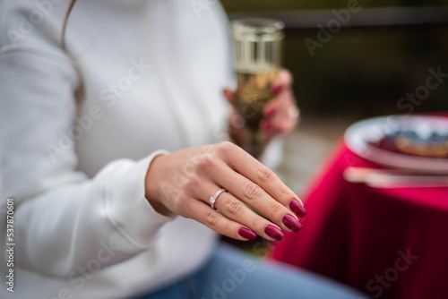 Close up of hands of woman showing the ring with diamond. She is engaged.