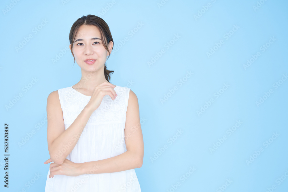 ノースリーブを着た若い女性と青背景 ノースリーブを着た若い女性と青背景