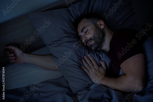 Obraz na plátně Close-up of handsome bearded man sleeping in bed at home enjoying good sleep, to