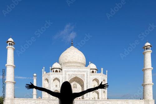 Woman with open arms admiring the Taj Mahal. Agra, Rajasthan (India).