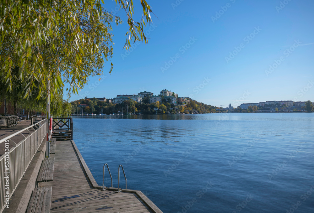 Piers at the bay Alviks Strand, boat club apartment and office building a sunny a color full autumn day in Stockholm
