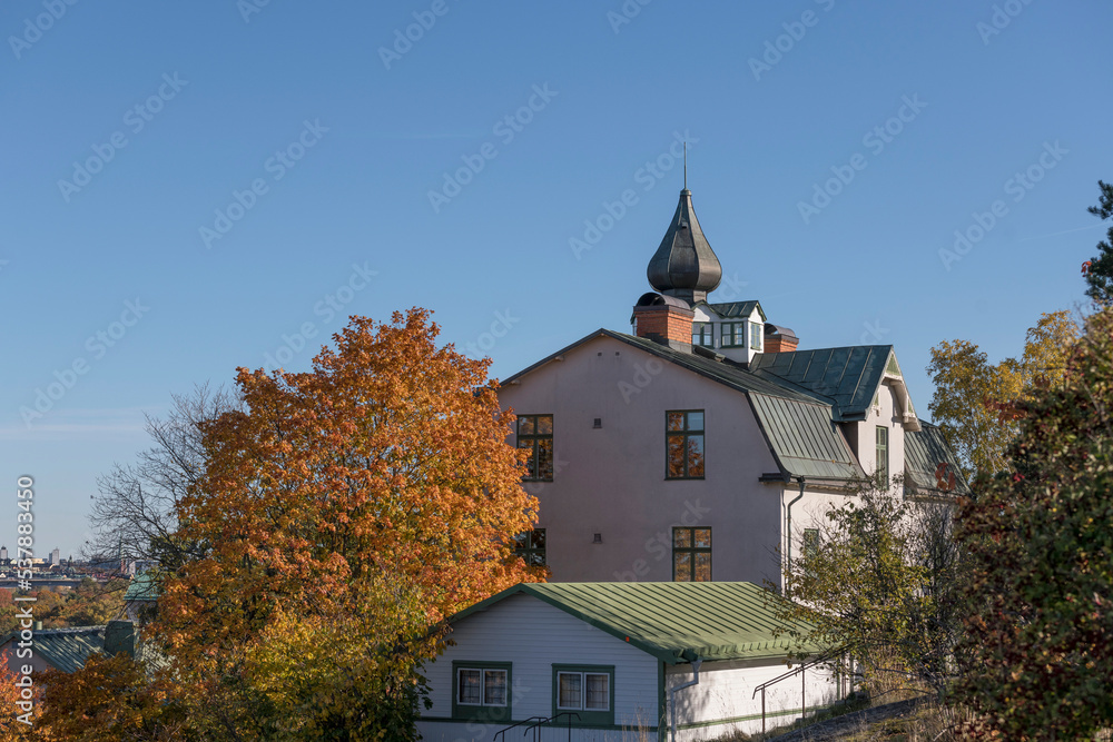 Old 1904s apartment building with an onion dome, on the hill Ormberget a sunny a color full autumn day in Stockholm