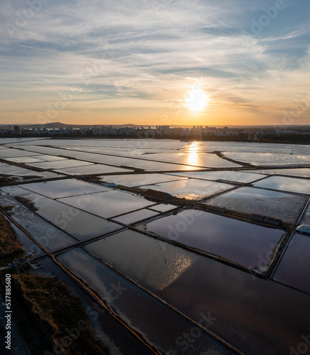 Ariel View of a Sunset behind the city Over the saltworks Salt Lake