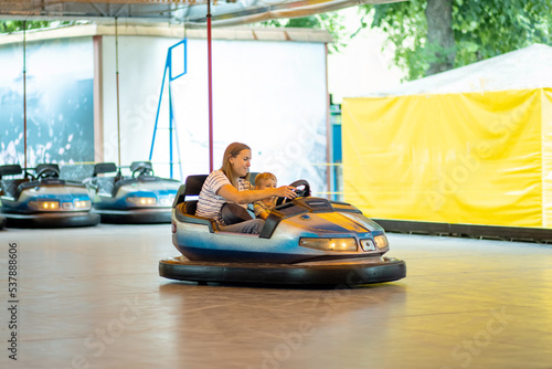 Mother and son having ride in the bumper car at the amusement park