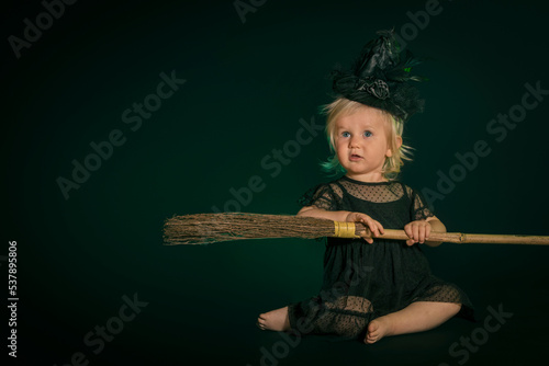 Cute blond little witch in black dress