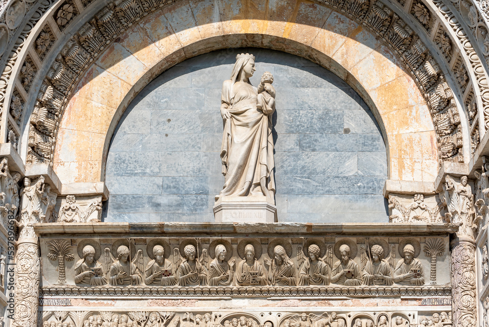 Close-up on Madonna´s marble statue decorating the exterior facade of catholic basilica in Pisa