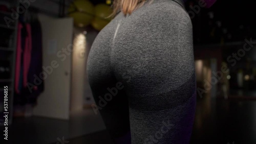 Back view closeup of woman in sexy sport leggings. Blow to the buttock. slow motion photo
