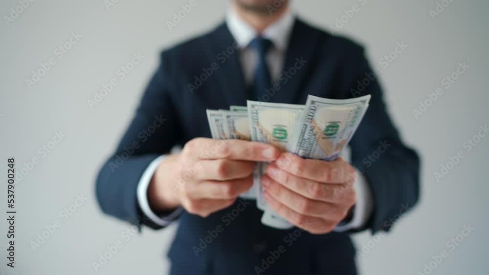 Formally dressed man counting US Dollar bills, close-up. Formally dressed man counting US Dollar bills, close-up.